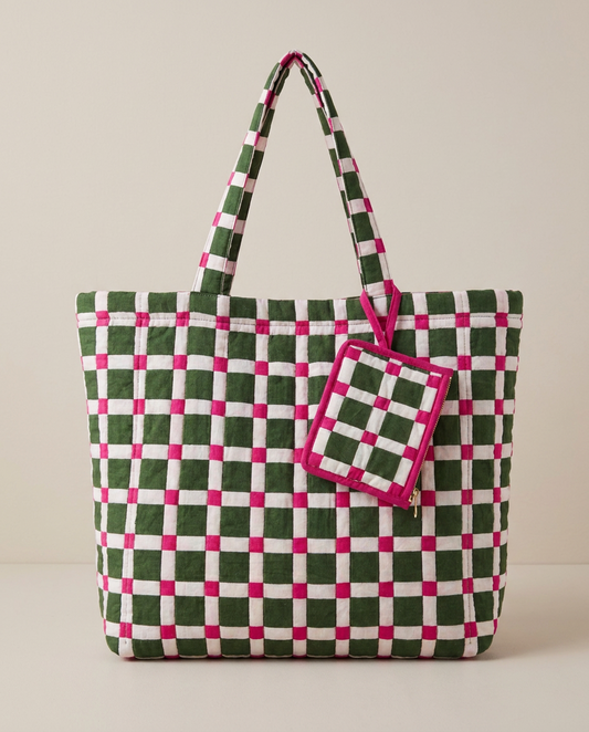 A woven tote bag with a green, white, and pink checkered pattern, featuring dual shoulder straps and a matching zippered pouch attached on the side, set against a plain beige background.