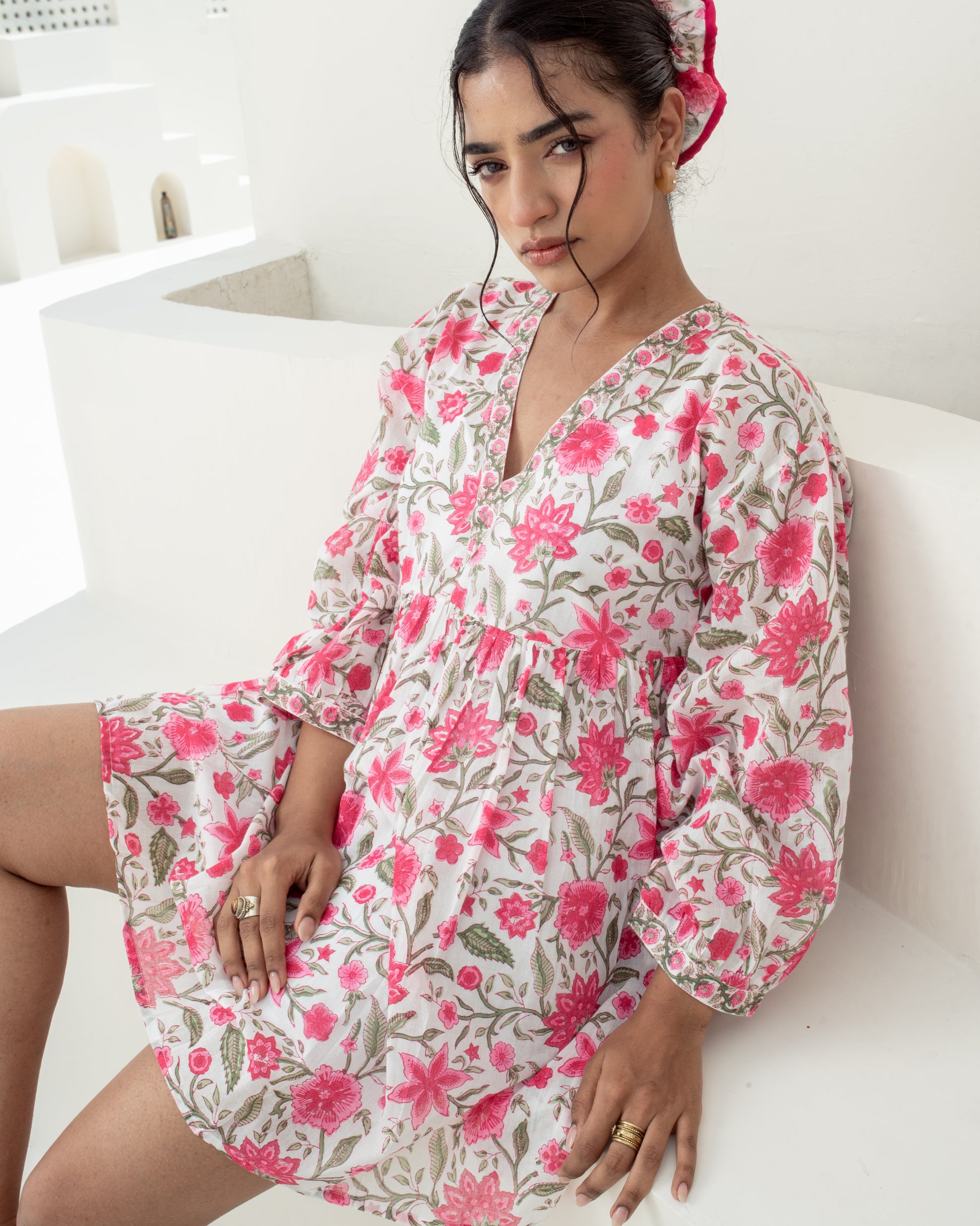 Model wearing the Anar Bagh pink floral hand block printed cotton mini dress front closeup neckline and sleeves