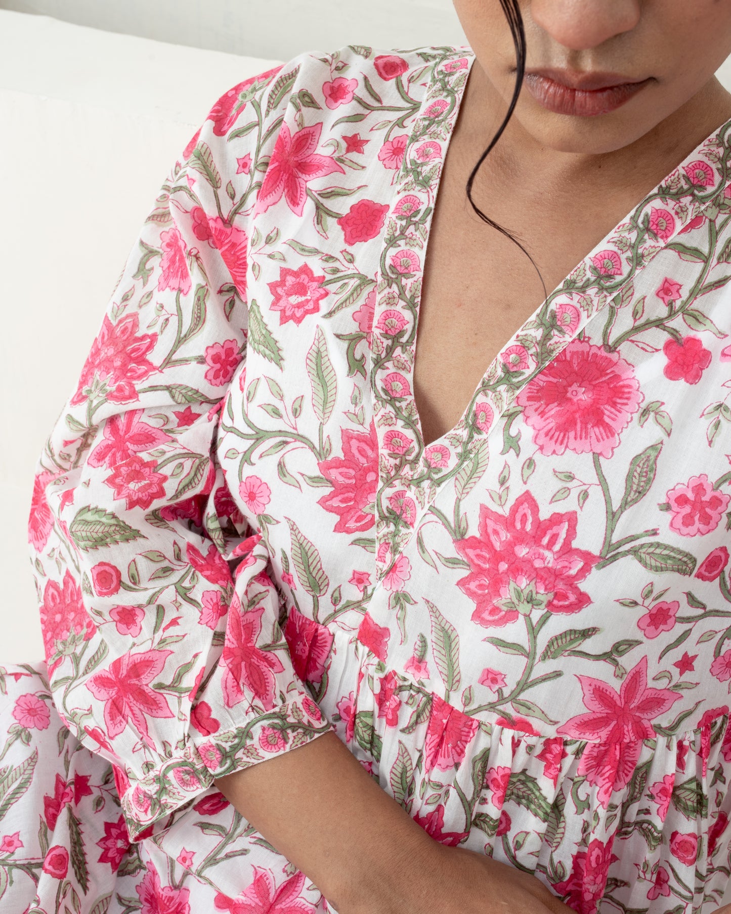 Model wearing the Anar Bagh pink floral hand block printed cotton mini dress closeup