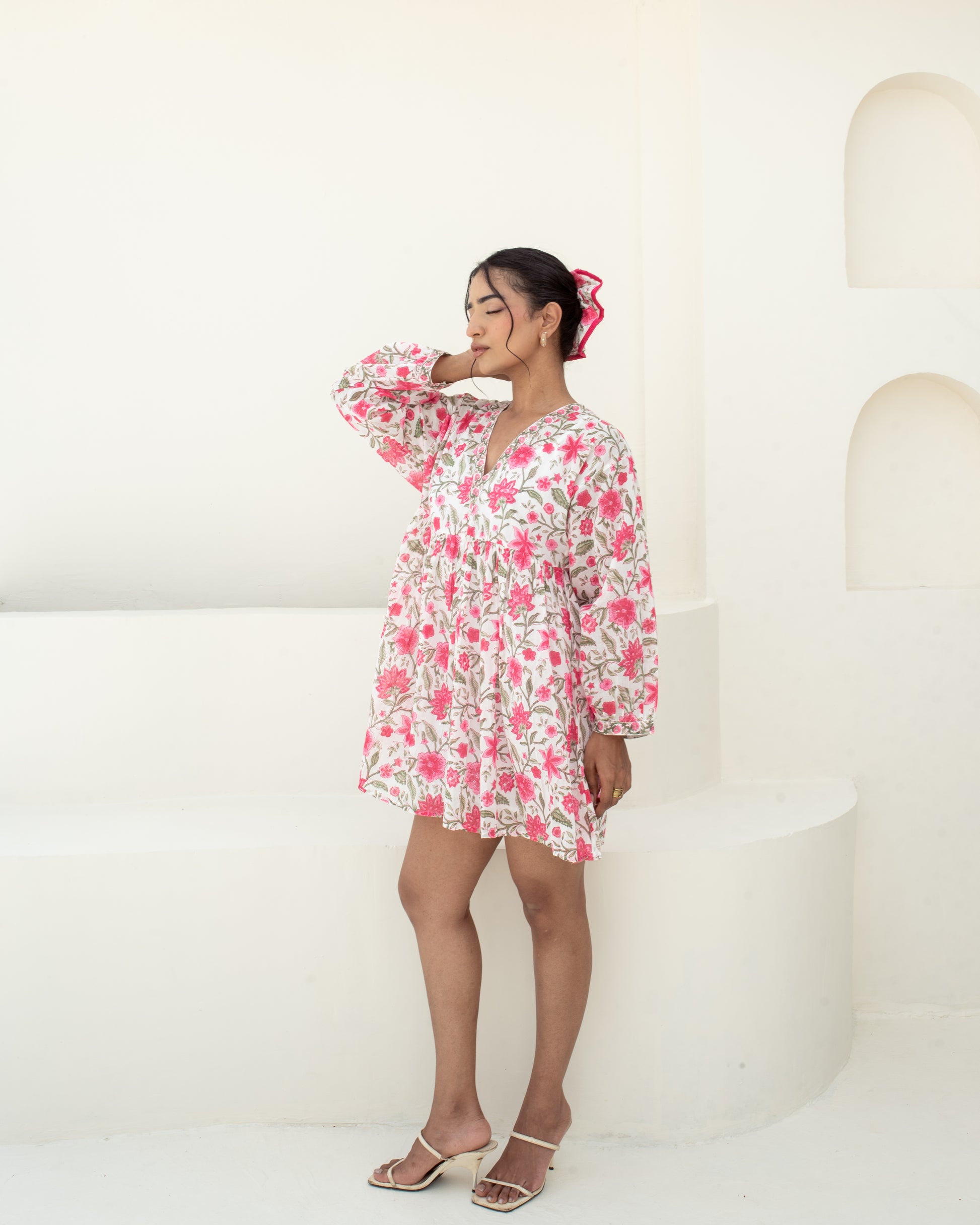 Model wearing the Anar Bagh pink floral hand block printed cotton mini dress side details with sleeves