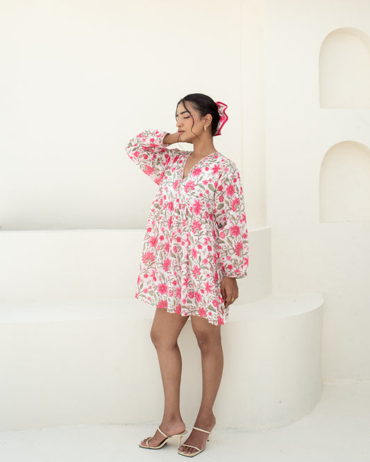 Model wearing the Anar Bagh pink floral hand block printed cotton mini dress side details with sleeves
